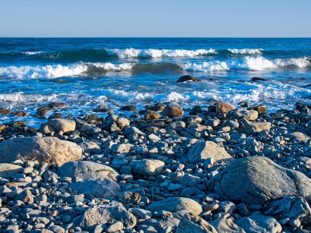 Большие камни на берегу моря с белыми волнами