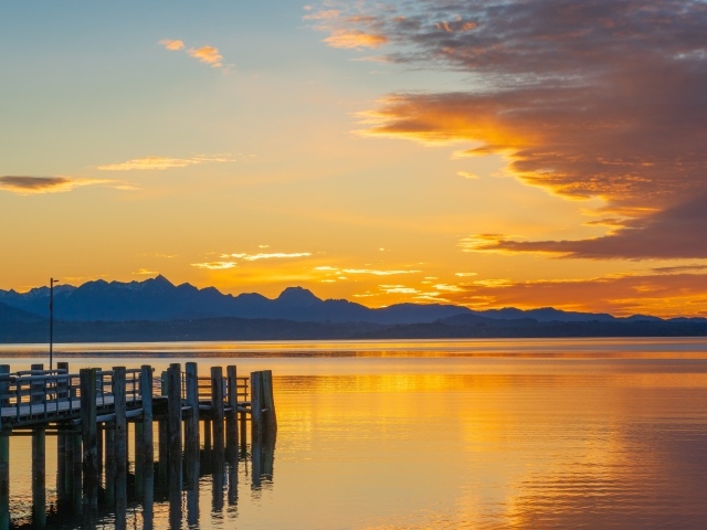 Красивый закат в небе над тихой водой озера