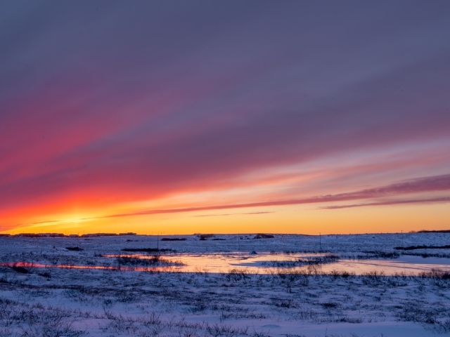 Закат солнца над покрытым снегом полем Аляски