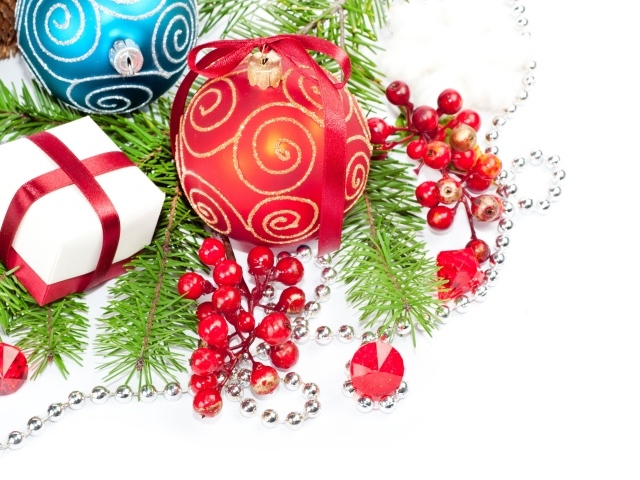 Разноцветные елочные игрушки с ветками на белом фоне