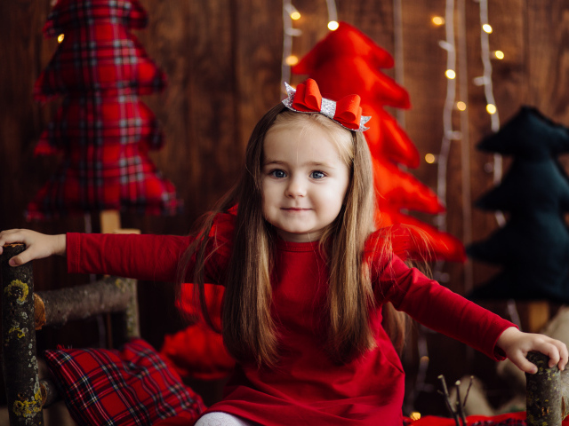 Красивая маленькая длинноволосая девочка в красном платье