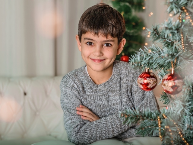 Кареглазый мальчик у новогодней ели