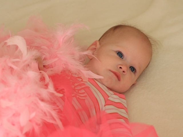 Милая малышка с розовыми перьями