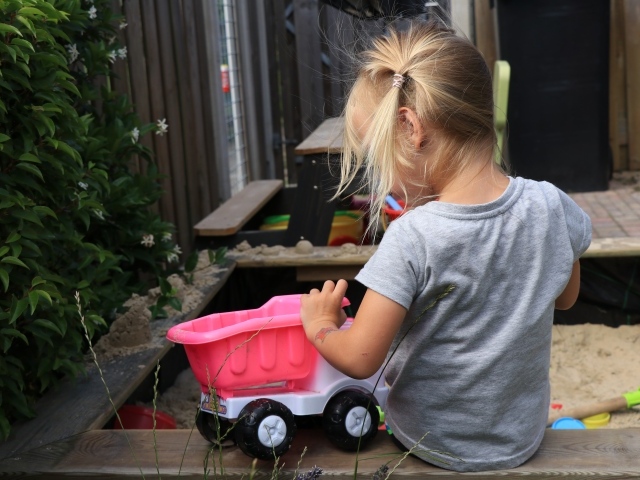 Девочка играет с игрушечной машинкой