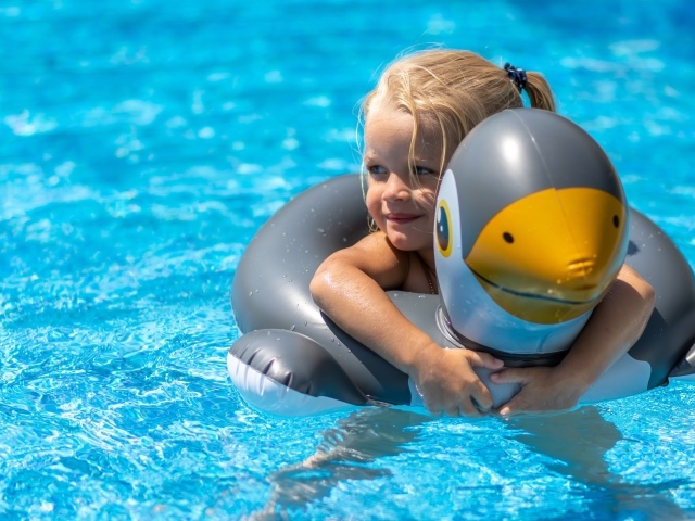 Девочка со спасательным кругом в бассейне