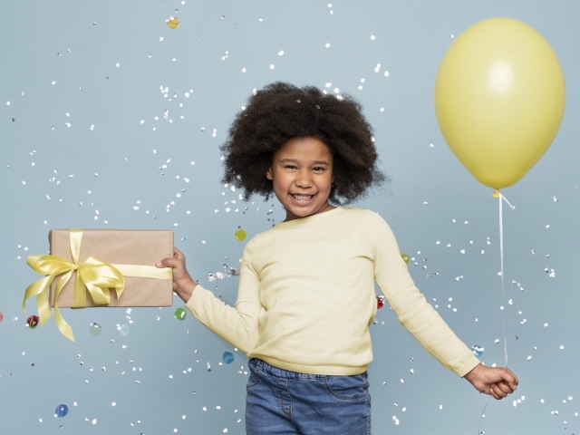 Счастливая девочка с подарком и шариком на голубом фоне