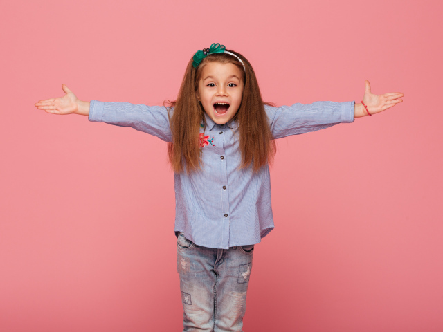 Счастливая маленькая девочка на розовом фоне