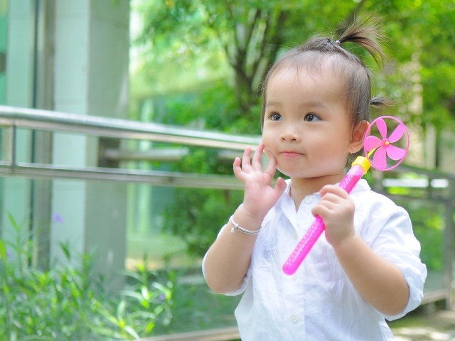 Маленькая девочка азиатка с игрушкой в руках