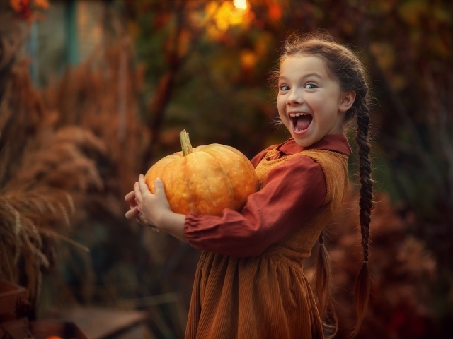Маленькая рыжеволосая девочка с тыквой