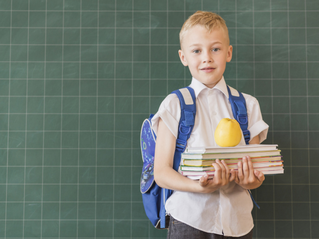 Мальчик школьник с книгами у доски