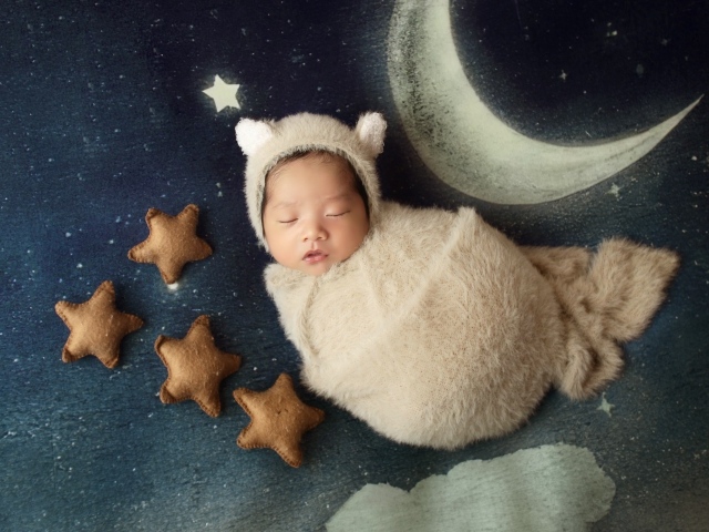 Спящий новорожденный ребенок с декором для фото 