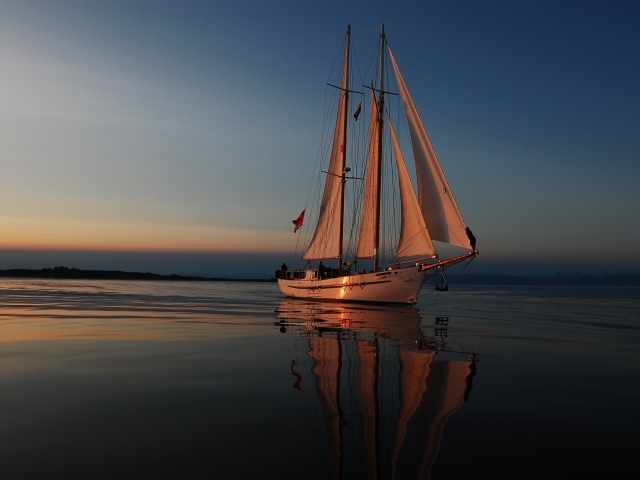 Большая парусная яхта в море на закате