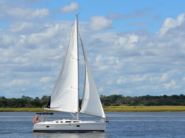 Яхта с белыми парусами на реке