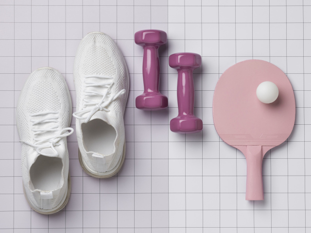 Гантели, ракетка с мячом и кроссовки на клетчатом фоне