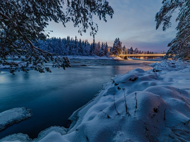 Покрытая льдом река с заснеженными берегами