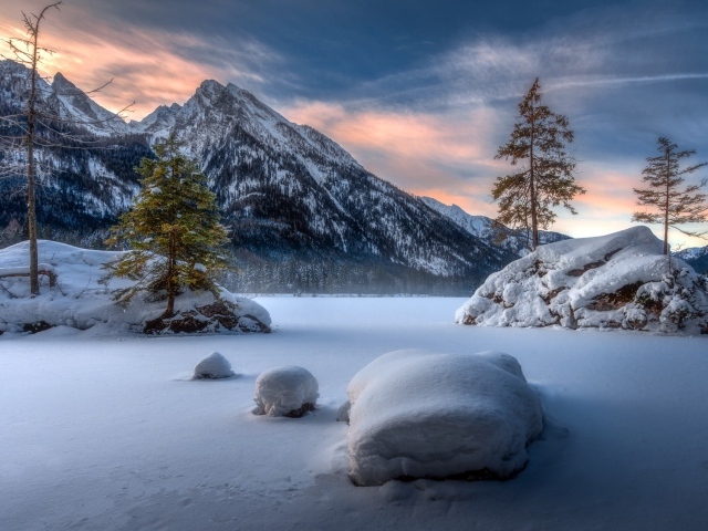Большие камни покрыты белым снегом в горах