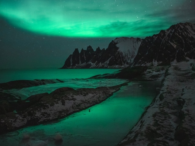 Зеленое полярное сияние над горами в Норвегии