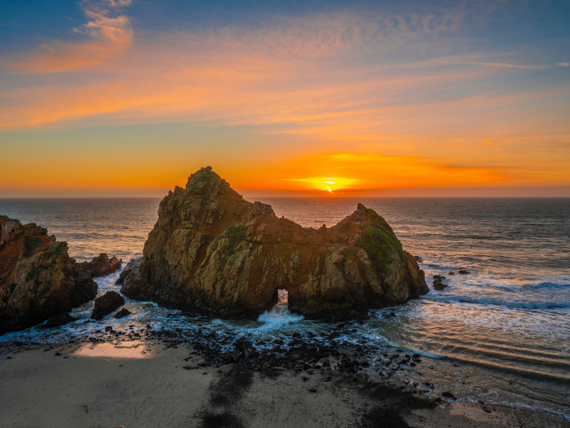 Вид на скалу в море на закате солнца, США