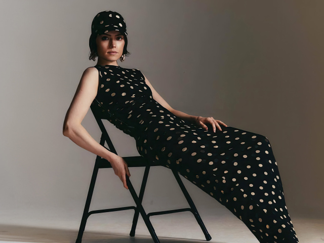 Актриса Дейзи Ридли в черном платье сидит на стуле