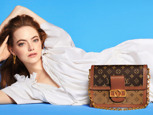 Актриса Эмма Стоун с сумочкой Louis Vuitton на голубом фоне