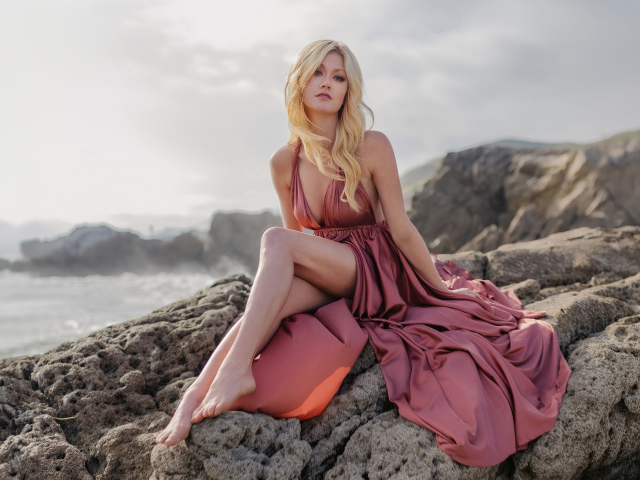 Актриса Кэтрин Макнамара сидит на камне у моря