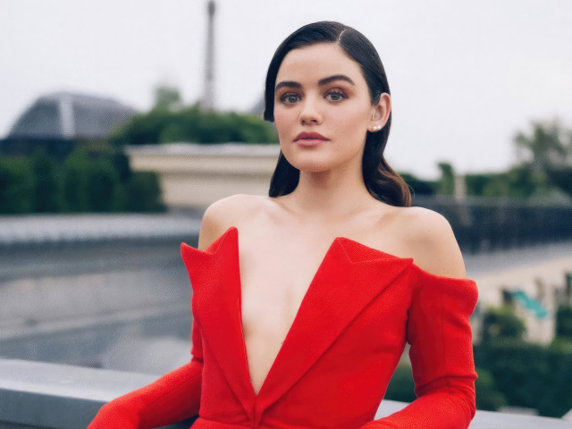 Актриса Люси Хейл в красном наряде стоит на мосту