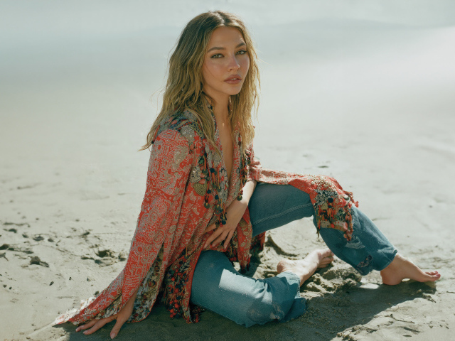 Актриса Мэдлин Клайн сидит на песке