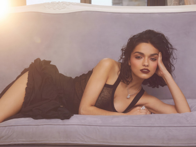 Актриса Рэйчел Зеглер в черном платье лежит на диване