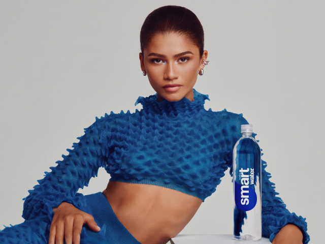 Актриса Зендея в голубом костюме с бутылкой воды
