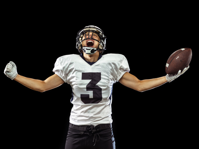 Игрок в американский футбол с мячом в руке