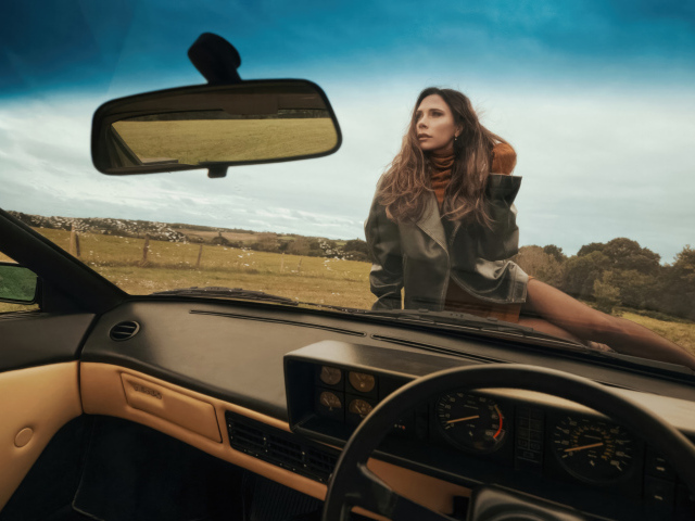 Красивая девушка Виктория Бекхэм сидит на машине
