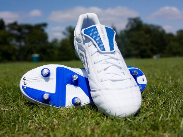 Красивые новые футбольные бутсы на зеленой траве 