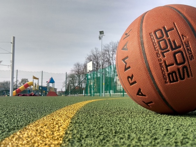 Большой коричневый баскетбольный мяч на поле