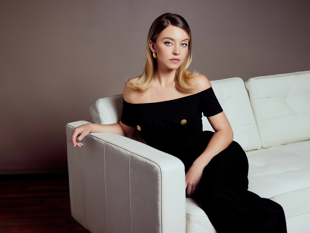 Милая девушка Сидни Суини в черном платье на диване