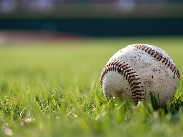 Грязный бейсбольный мяч на зеленой траве на поле