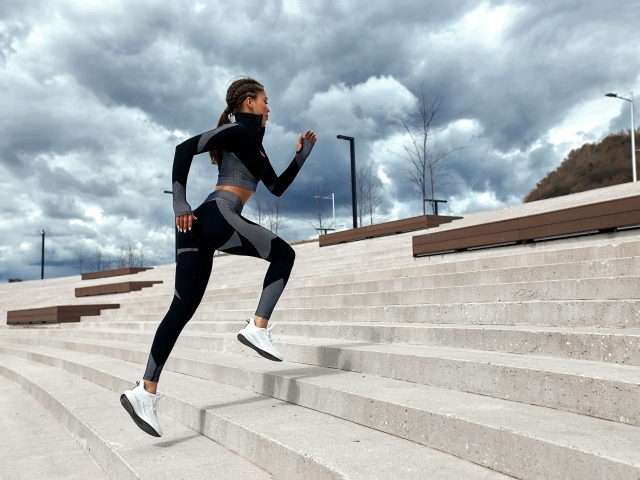 Девушка спортсменка бежит по лестнице