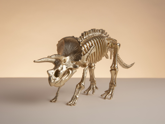 Золотой скелет динозавра на коричневом фоне