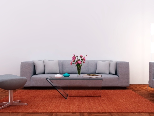 Большой серый диван в комнате с серой стеной