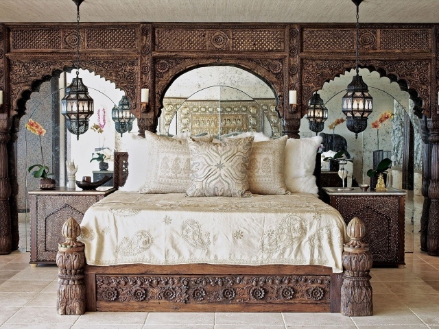 Большая деревянная кровать в комнате с резными стенами