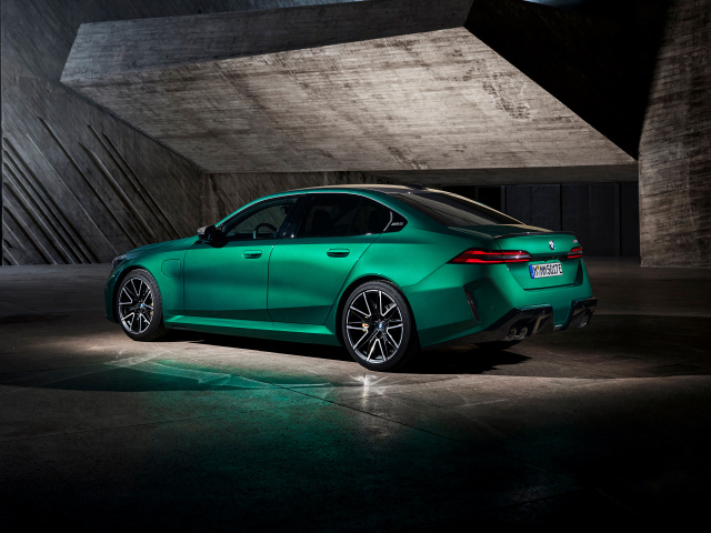 Вид сзади на зеленый автомобиль BMW M5 2024  года