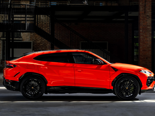 Вид сбоку на красный внедорожник Lamborghini Urus