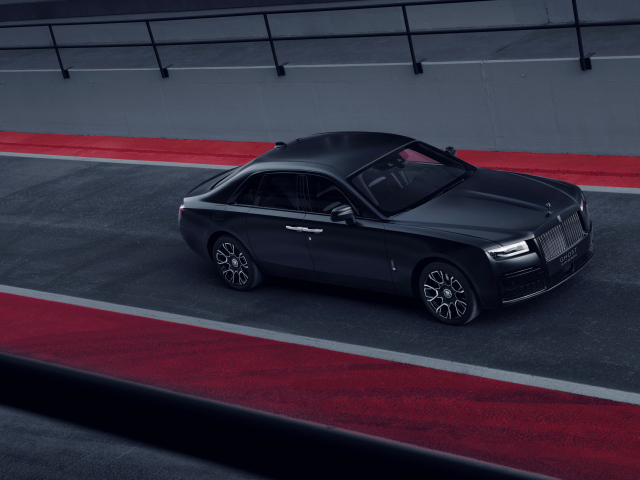 Черный автомобиль Rolls-Royce Black Badge Ghost на дороге