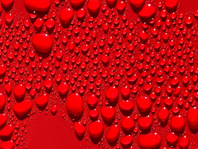 Капли воды на ярком красном фоне