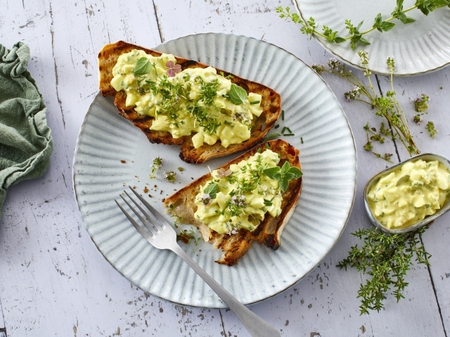 Гренки с кремом и зеленью на тарелке