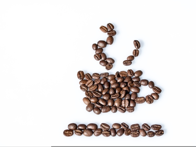 Чашка из кофейных зерен на белом столе