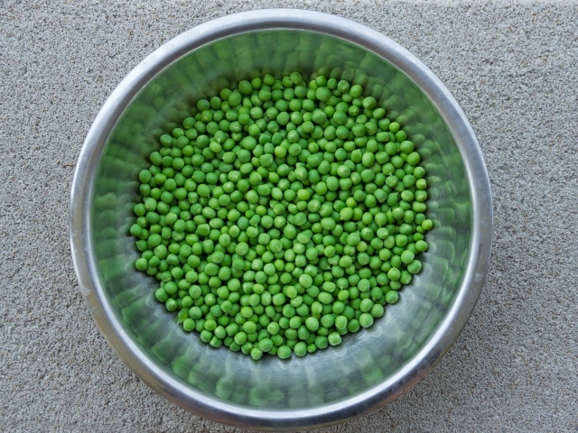 Зеленый горошек в жестяной миске на столе