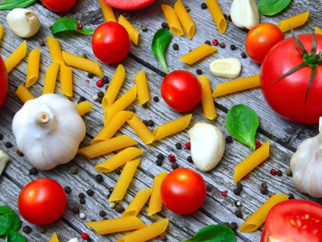 Макароны на столе с помидорами и чесноком