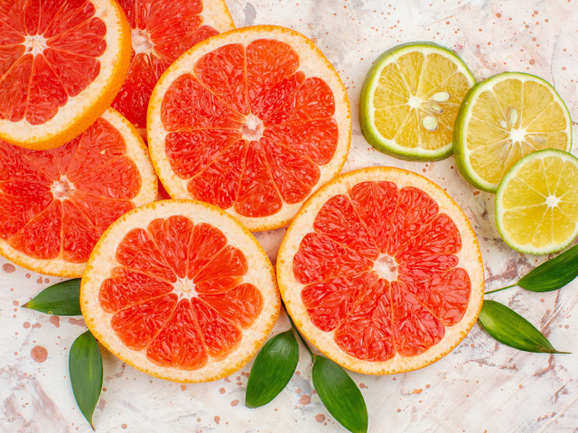 Грейпфрут и лимон нарезанные кусочками на столе