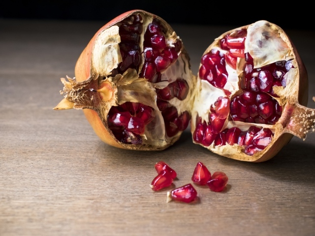 Половины плода граната на столе