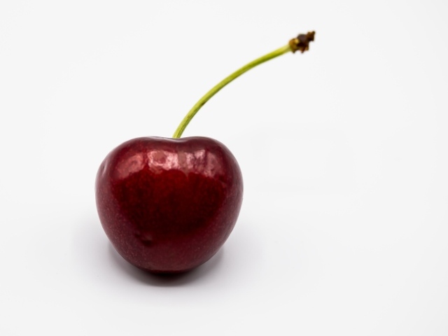 Крупная красная черешня на белом фоне
